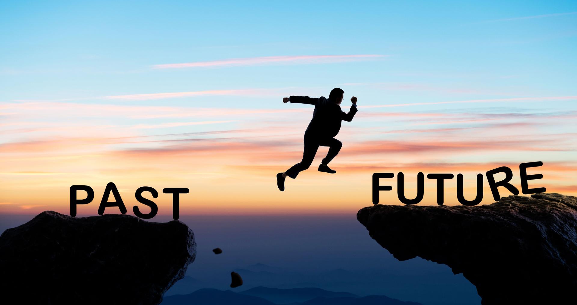 Businessman jumping cliff from past to future